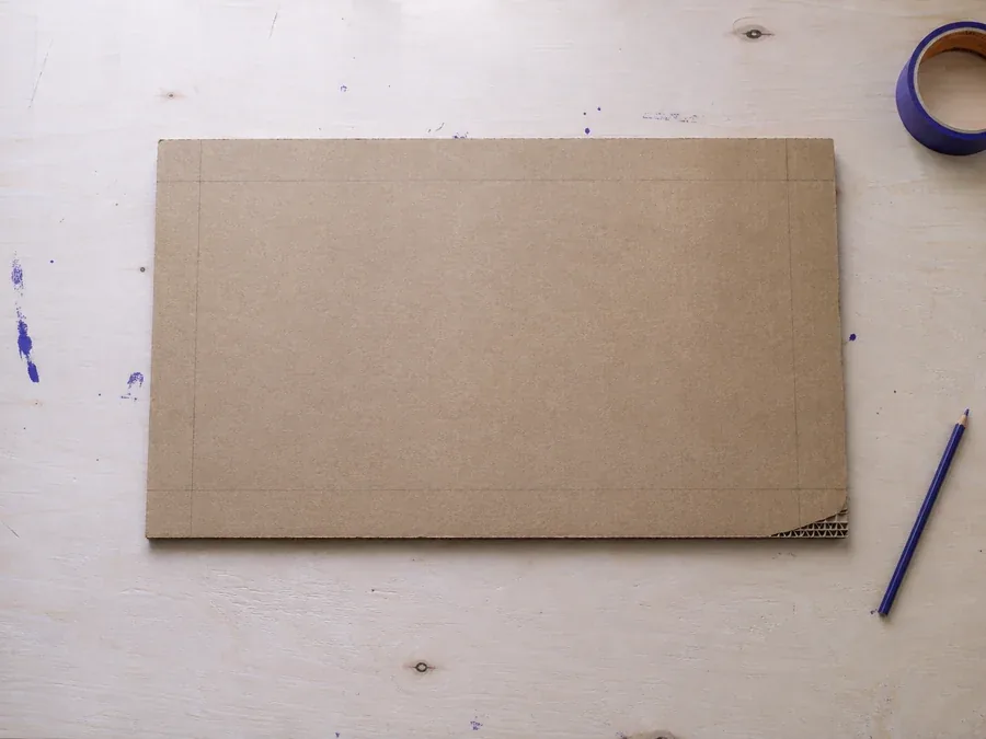 Base de cartón recortada sobre la mesa de trabajo, vista desde arriba